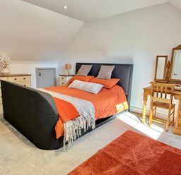 A bedroom with a bed and dresser at Charming Barn Annex with Stables New Forest Escape