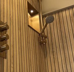 A shower with water control knobs and wooden wall paneling at Llysawelon 2-Bed Cottage, Sleeps 5, Pets Ok, Llysawelon near Llansteffan