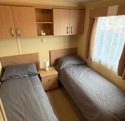 A bedroom with two beds and a nightstand at 2-Bed Caravan, Sleeps 6 w/ Parking, No Pass Needed