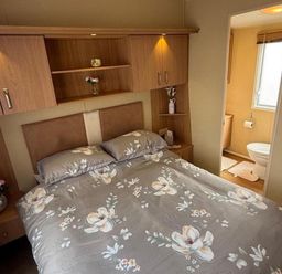 A bedroom with a bed and attached bathroom at 2-Bed Caravan, Sleeps 6 w/ Parking, No Pass Needed