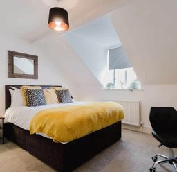 A bedroom with a bed and desk at Licatas Apartment Cirencester Cotswolds Sleeps 6