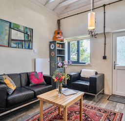 A living room with a sofa, chairs, and a table at Little Linney Sleeps 2 Garden  Parking  Wifi Hartland