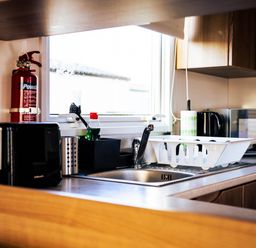 A kitchen with a sink, toaster, and fire extinguisher at Captivating 6-Person Caravan in Rhyl