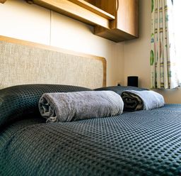 A bed with pillows and towels in a bedroom at Captivating 6-Person Caravan in Rhyl