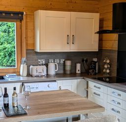 A kitchen with cabinets and appliances at Pet Friendly - Lodge at Riverview Holiday Park, Mangerton near Newcastleton