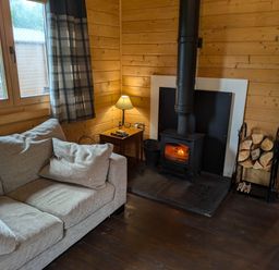 A living room with a sofa and fireplace at Pet Friendly - Lodge at Riverview Holiday Park Mangerton near Newcastleton