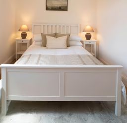 A bedroom with a bed and nightstands at Foundry Farm Apartment