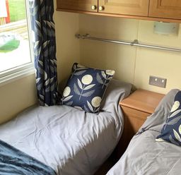 A bedroom with two beds and a bedside table at Static Caravan 2 Bedrooms - sleeps 4 in Hawick
