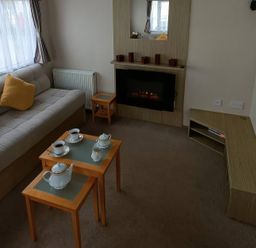 A living room with a sofa, coffee table, and tea set at 3 Bed, Sleeps 6, Parking