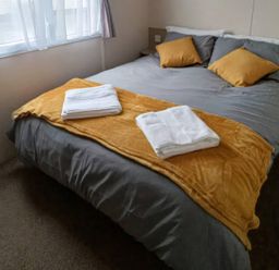 A bedroom with a bed and towels at 3 Bed, Sleeps 6, Parking