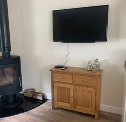 A living room with a wood stove and a television at TBC
