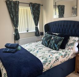 A bedroom with a bed and bedside table at TBC