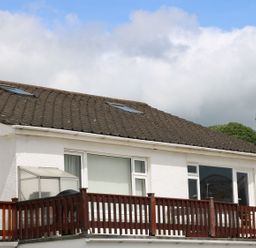 A house with a balcony and windows at The Cartwheel in Amroth