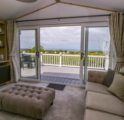 A living room with a sofa and television at The Dorchester at Bay View in New Quay