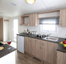 A kitchen with a sink and fridge at Tide’s Reach - Hayling Island