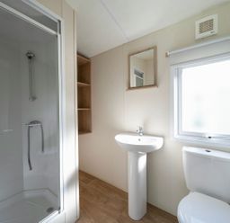 A bathroom with a shower, sink, and toilet at Tide’s Reach - Hayling Island