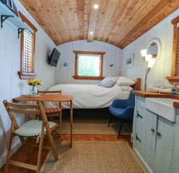 A bedroom with a bed, table, and sink at Ardwyn in Pwllheli