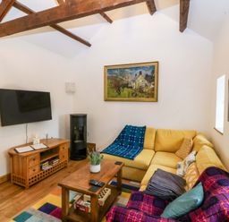 A living room with a sofa and coffee table at Ty Loti 
