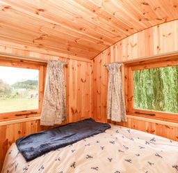 A bedroom with wooden walls and windows at Laurel in Welney near Littleport