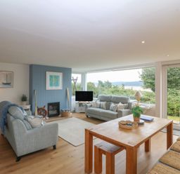 A living room with a sofa and dining table at Red Wharf Retreat near Red Wharf Bay