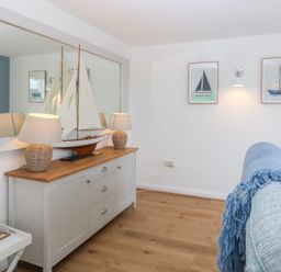 A living room with a sailboat on a table at Red Wharf Retreat Red Wharf Bay near Benllech
