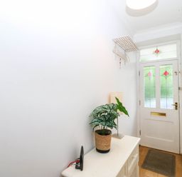 A hallway with a plant and console table at Llys Awen Caernarfon
