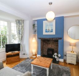 A living room with a television and a fireplace at Llys Awen in Caernarfon