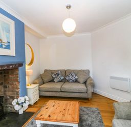 A living room with a sofa and coffee table at Llys Awen in Caernarfon