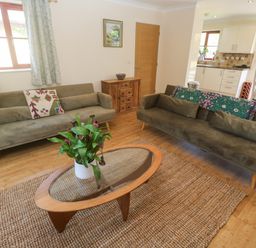A living room with two sofas, a coffee table, and a plant at Yonde View Camborne