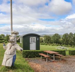 A cooking cow statue beside an outdoor shed at Shepherds Hut at East Hill Pride Four Elms Hill Nr. Sidmouth