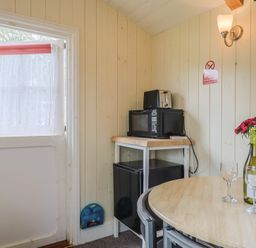 A kitchen with a table and chairs at Shepherds Hut at East Hill Pride Four Elms Hill Nr. Sidmouth