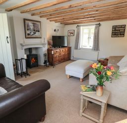 A living room with a sofa and a television at 2 The Gardens Lechlade