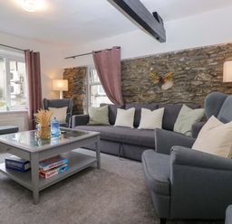 A living room with a sofa and coffee table at Courtyard Cottage in Cartmel