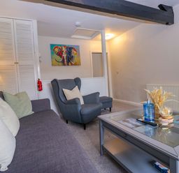 A living room with a sofa and armchair at Courtyard Cottage in Cartmel
