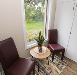 A snug with two chairs and a table at Mayfly Cottage