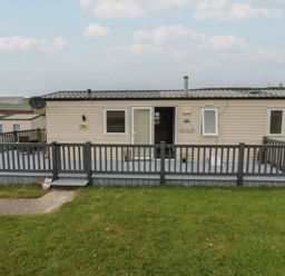 A caravan with a deck and steps at Tucked Away in Newquay