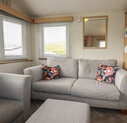 A living room with a sofa and cushions at Tucked Away in Newquay