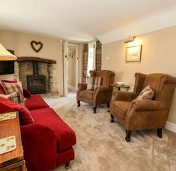 A living room with a sofa and armchairs at Little Wickers in Corfe Castle