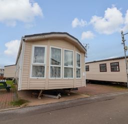 A mobile home with large windows and a porch in a residential area at Winchester - 478 Abergele
