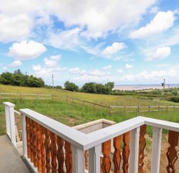 A view from a balcony overlooking a grassy field at Hay Loft at Ebenezer Chapel, Milwr