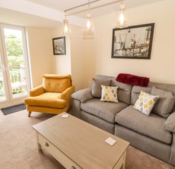 A living room with a sofa and armchair at Twyni Bach