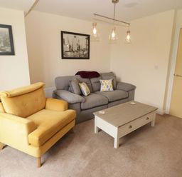A living room with a sofa and armchair at Twyni Bach