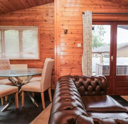 A dining area with a glass table and chairs at 89 Ambleside White Cross Bay