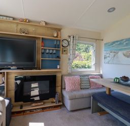 A living room with a television and sofa at Porthcurno 5 Perranwell near Goonhavern