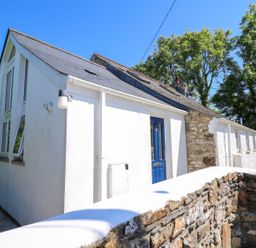 An exterior view of a white house with blue door at Tegfan Newport
