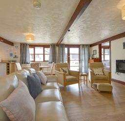A living room with sofa, chairs, and a table at Pillhead Cart Linhay in Bideford
