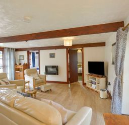 A living room with a television and seating area at Pillhead Cart Linhay in Bideford
