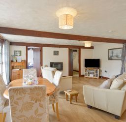A living room with a dining table and sofa at Pillhead Cart Linhay in Bideford