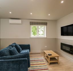 A living room with a sofa and coffee table at Foxglove near Stratton Audley
