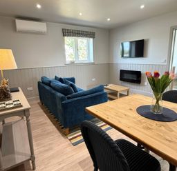 A living room with a sofa and dining table at Foxglove in Stratton Audley near Bicester